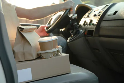 A takeaway order sitting on the car passenger seat