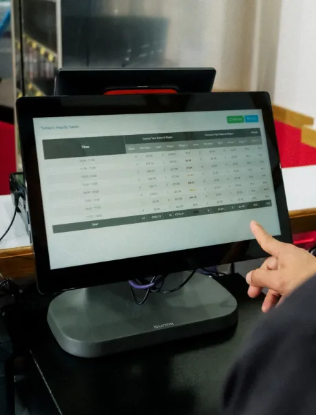 A hand hovering over a Flipdish POS showing hourly sales