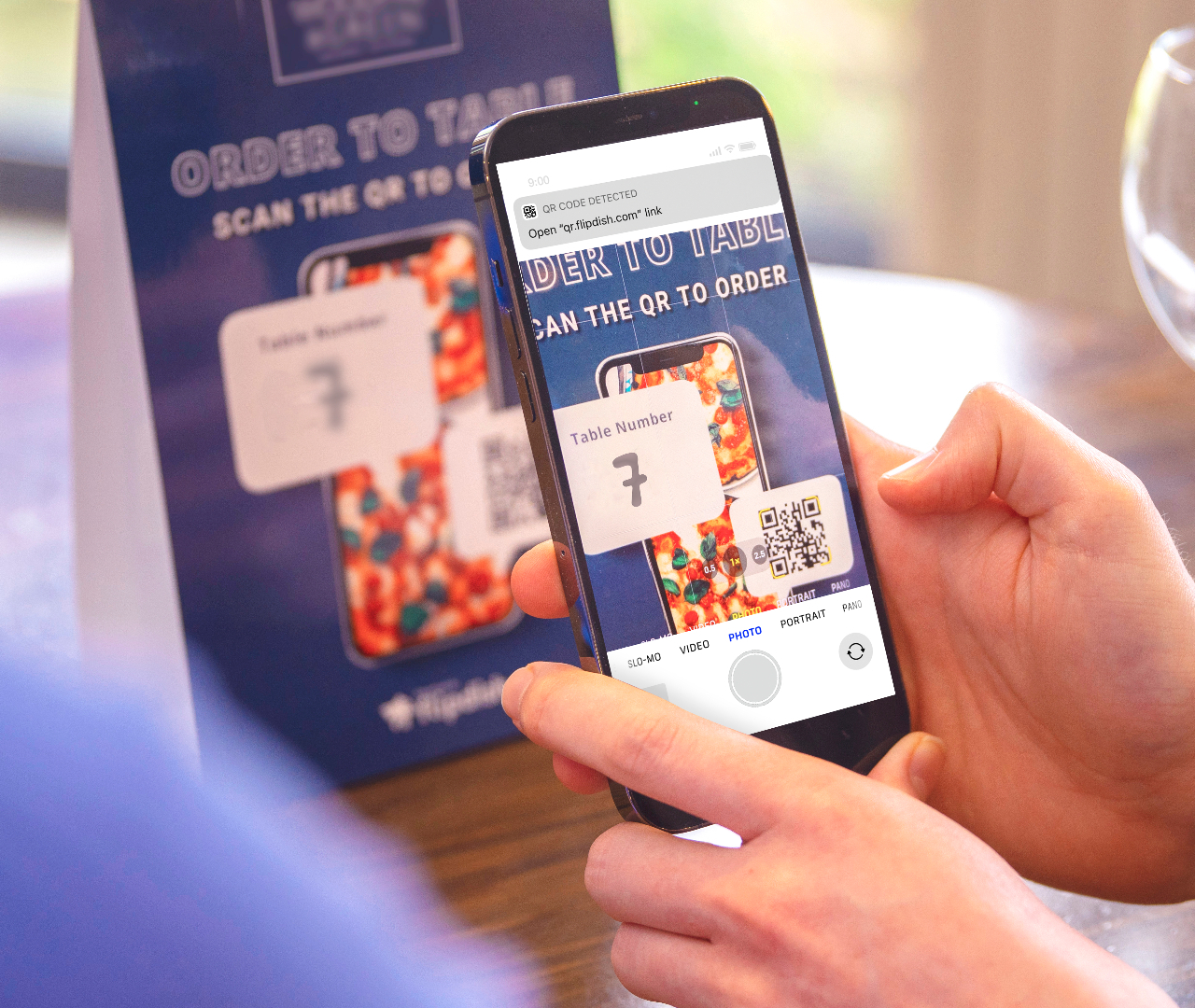 A smartphone operator scans a QR code menu tent