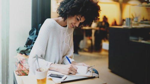 A woman writing on a clipboard in a restaurant