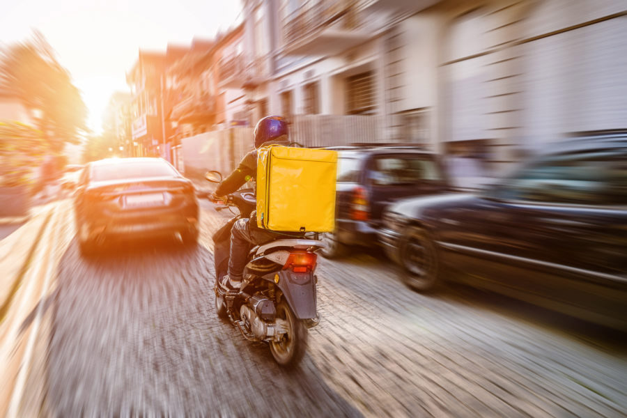 Food Delivery driver with an order out for delivery 900x600