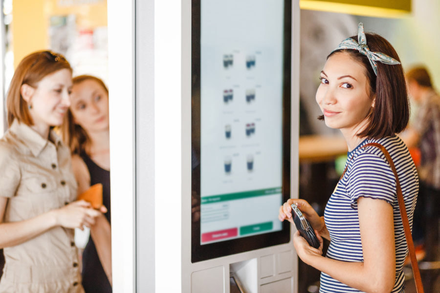 Women ordering from a kiosk menu