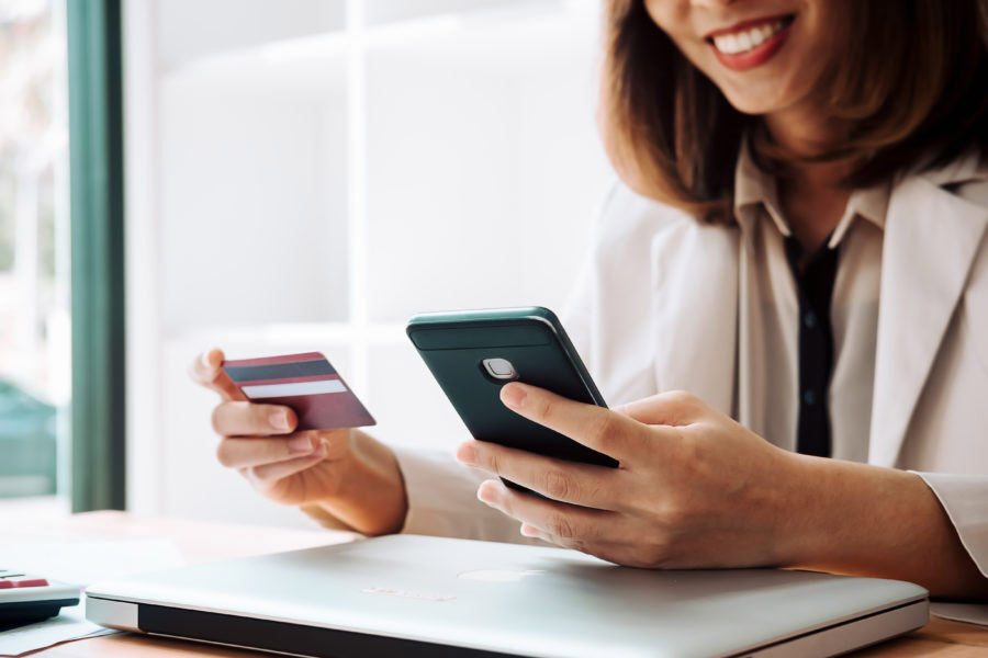 Woman paying with her card ordering from her mobile 900x600