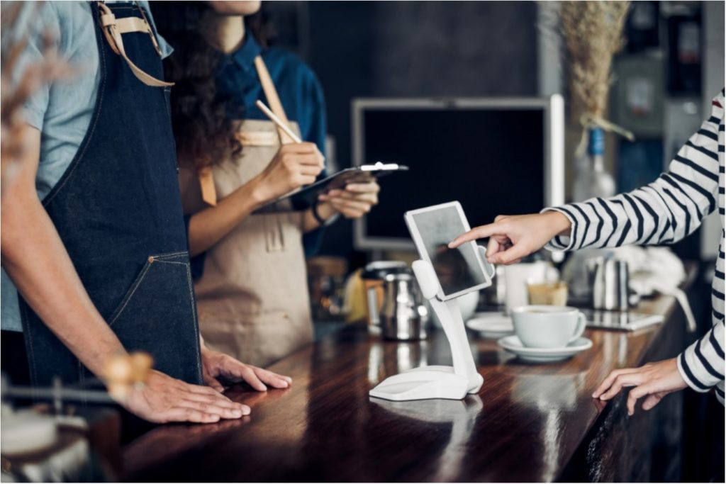 Customer orders on digital kiosk in restaurant